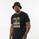 Man wearing a black t-shirt with motivational text on a plain background