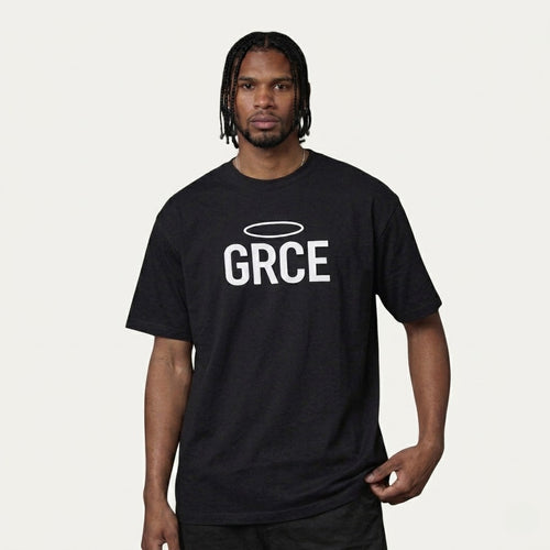 Person wearing a black t-shirt with 'GRCE' printed on it against a plain background