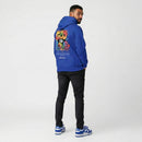 Person wearing a blue hoodie with colorful text on the back, standing against a white background