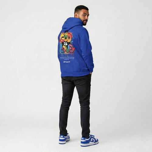 Person wearing a blue hoodie with colorful text on the back, standing against a white background