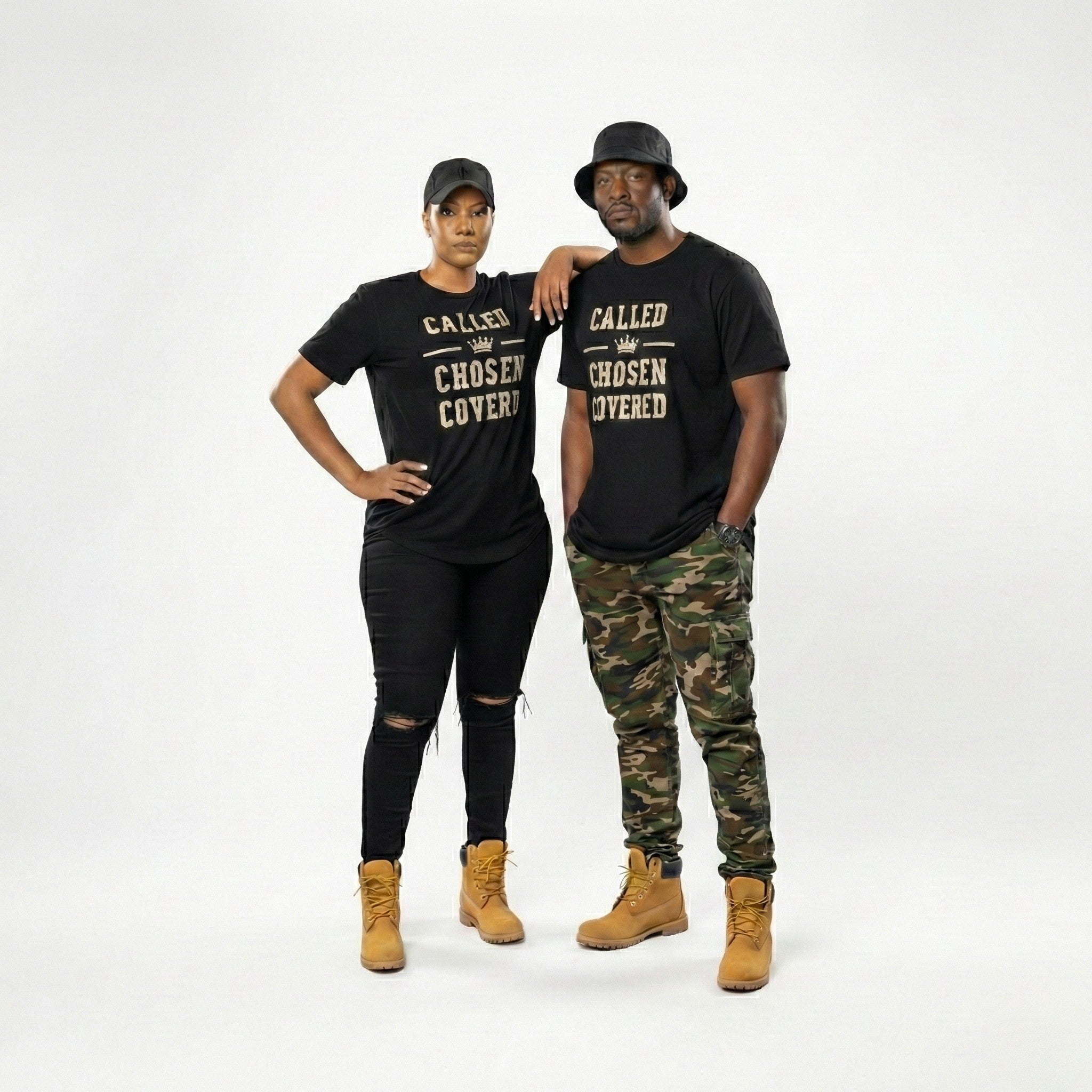 Two people wearing matching black t-shirts with text, standing against a white background.