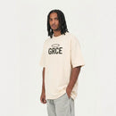 Man wearing a cream t-shirt with 'GRCE' logo on a white background